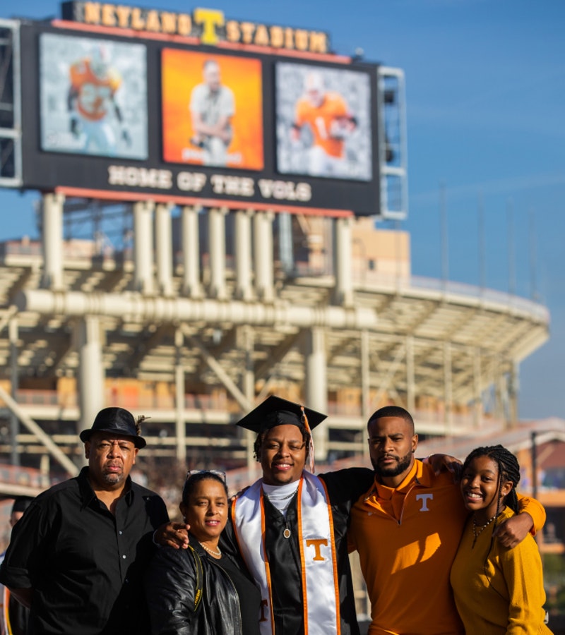 A family stands in front of UTK's Home of the Vols stadium on graduation day